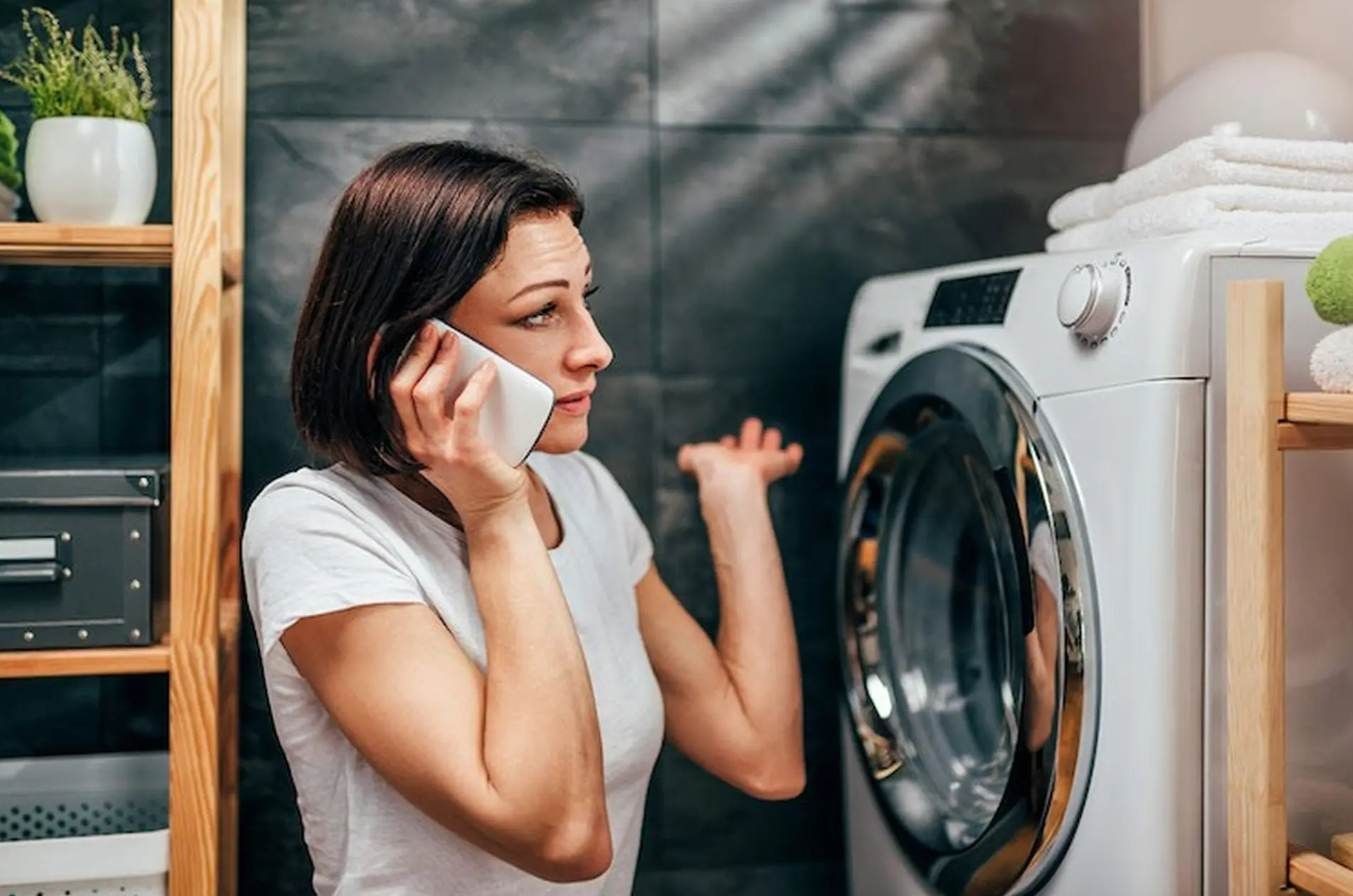 Một kỹ thuật viên đang kiểm tra bảng mạch điện tử của máy giặt để tìm lỗi