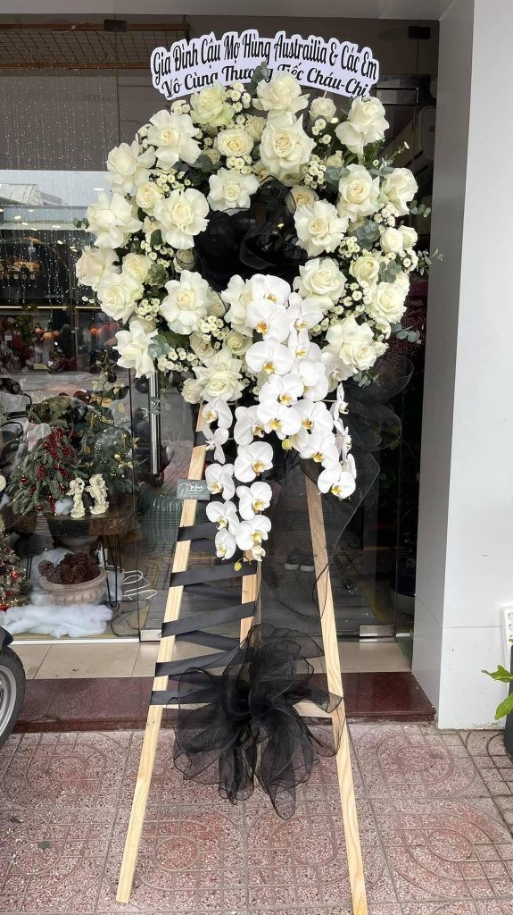 Vòng hoa tang lễ với hoa hồng trắng và các phụ kiện trang trọng