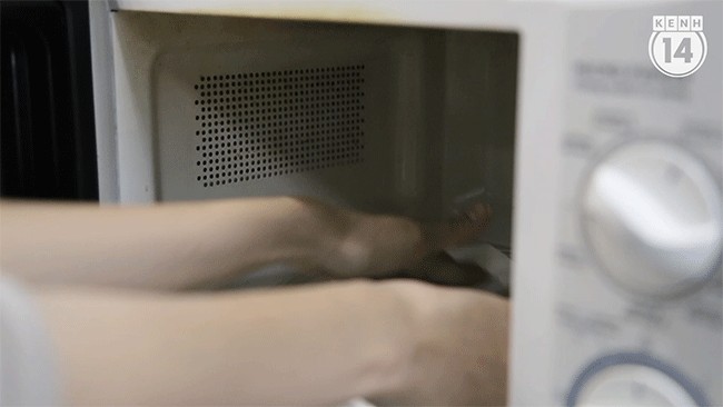 Phồng tôm đang nở bung trong lò vi sóng, miếng bánh chuyển màu trắng đục