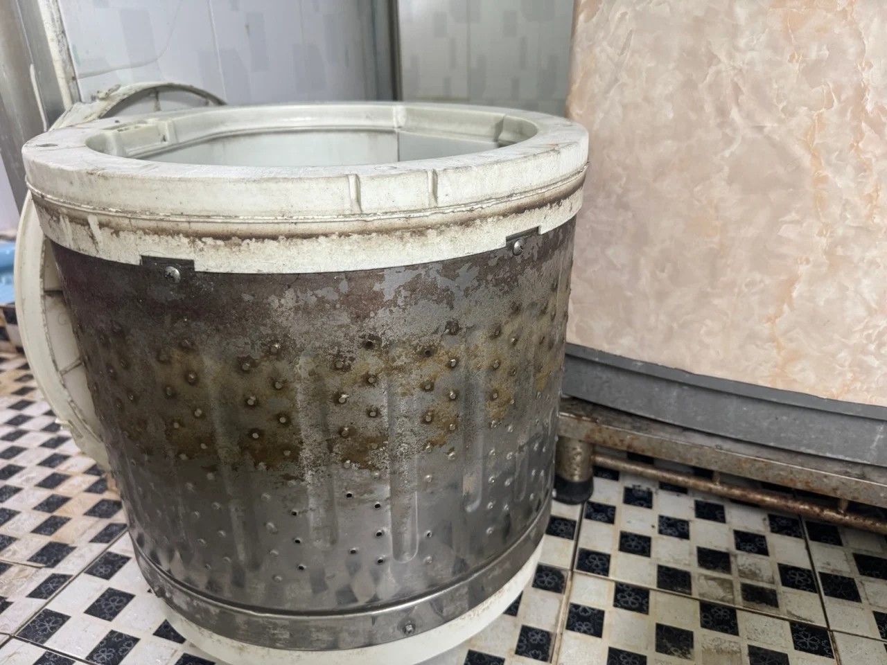 Lồng giặt bên ngoài bám đầy cặn bẩn và rêu mốc