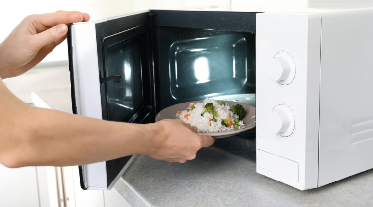 Món canh nóng hổi trong tô sứ đang được đặt trong lò vi sóng