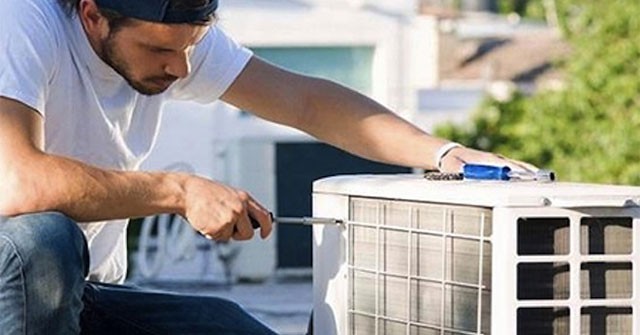 Thợ điện lạnh đang kiểm tra máy nén điều hòa
