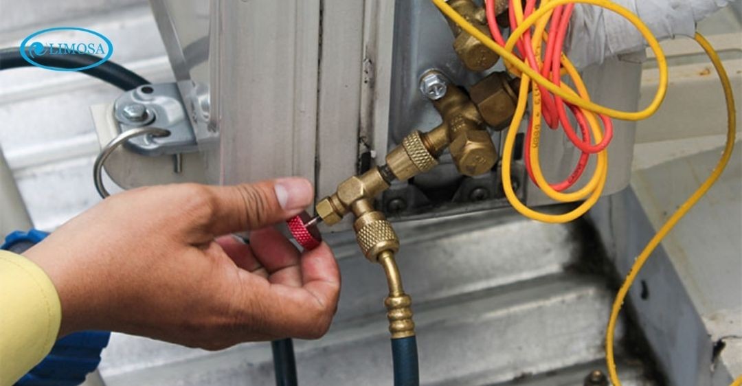 Kỹ thuật viên đang kiểm tra và siết chặt dây cáp tín hiệu của máy lạnh
